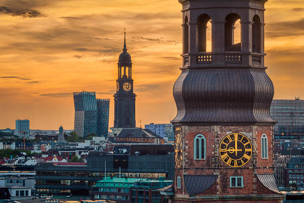 Church towers in Hamburg, Germany during sunset by Michael Abid
