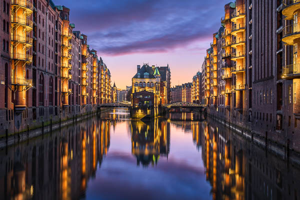 The famous Wasserschloss building in the historic Speicherstadt in Hamburg, Germany at night by Michael Abid